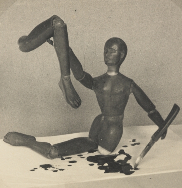 Photograph by Eric Lee-Johnson depicting an artist's mannequin holding a severed bloody leg, 1930