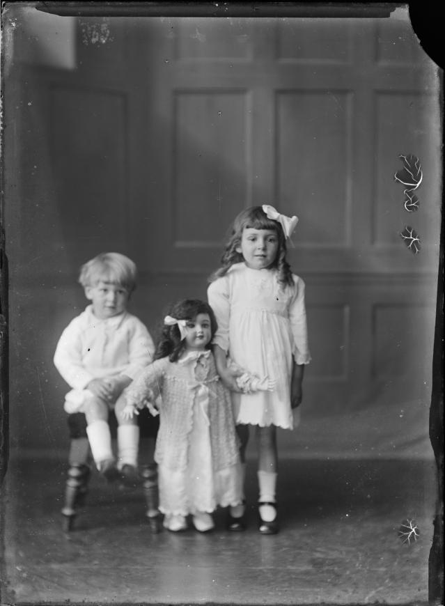 William Berry's studio portrait of two children with a large doll, circa 1920