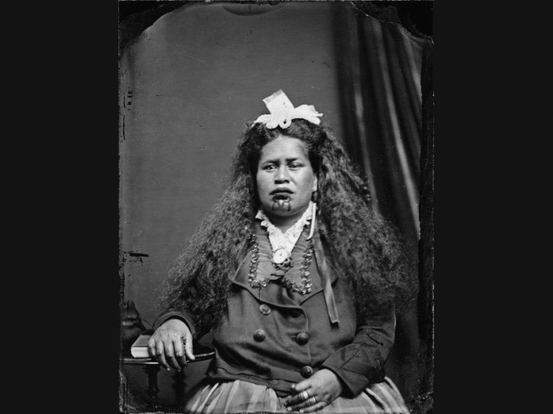 Black and white photo of a Māori woman wearing European clothes
