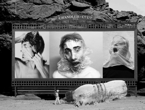 An old fashioned billboard stand in front of large rocks. In the billboard are three photos, each of a man with a plastic bag over his head, making three different faces, each suggesting a struggle. In front is an oversized soft drink bottle and a small astronaut