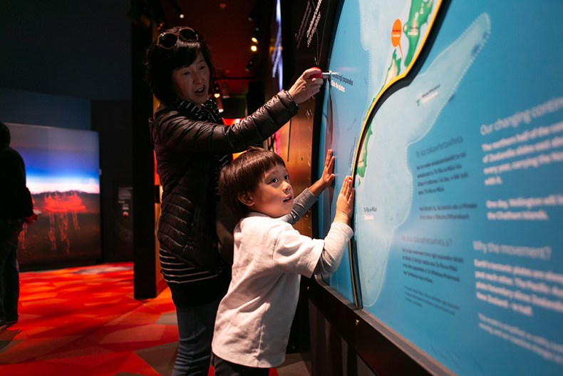 People looking at a map on a wall in an exhibition
