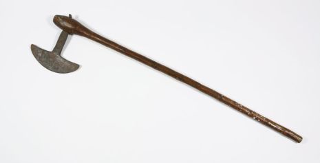 An axe. It has a long wooden handle and a T-shaped blade
