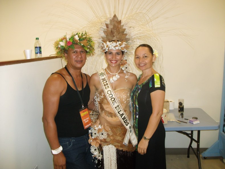 three people standing looking at a camera with costumes and headdresses
